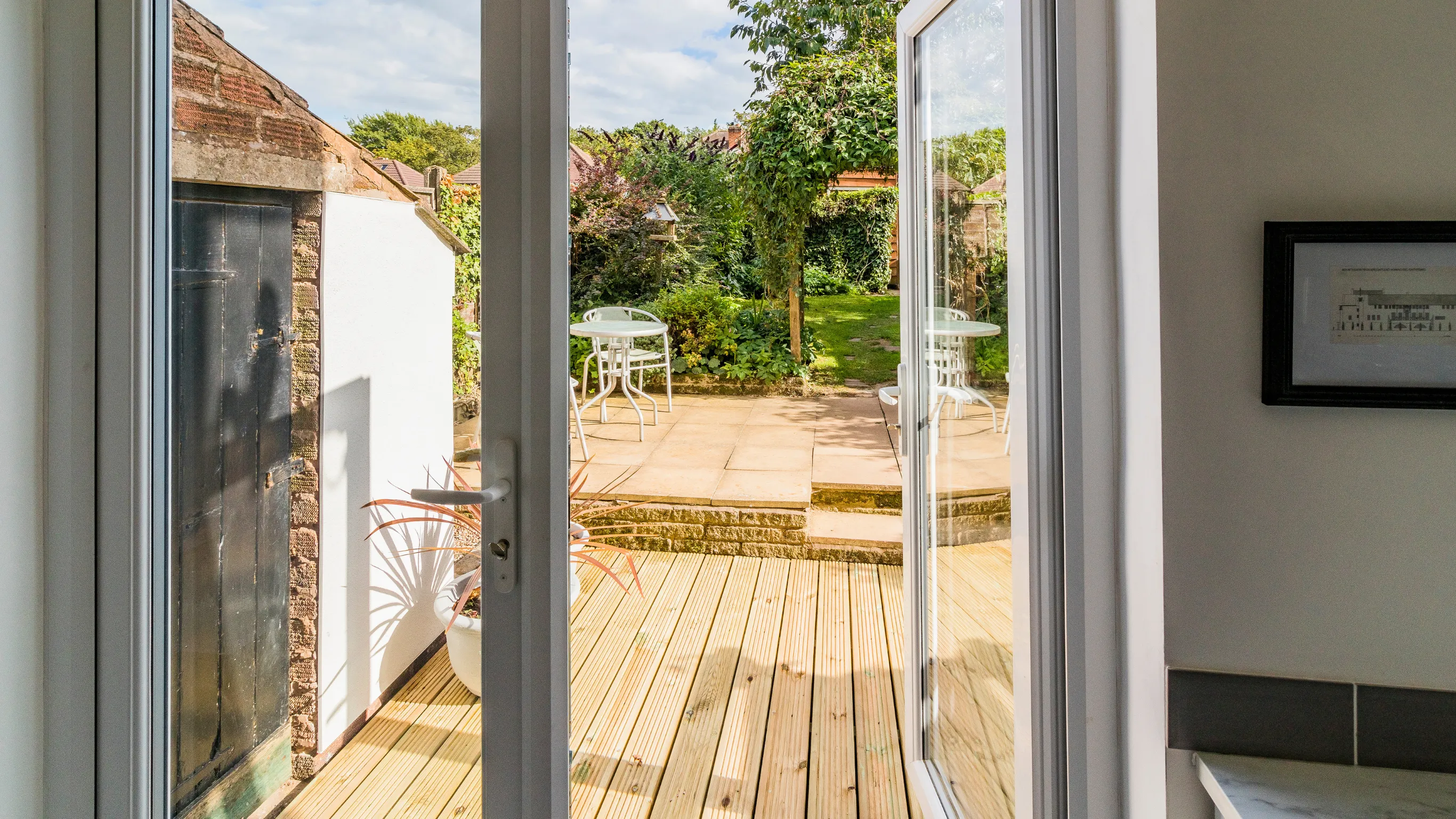Panoramic glass doors opening to a luxury wooden deck and garden in Los Angeles, creating a seamless transition by Dream Patios LA.