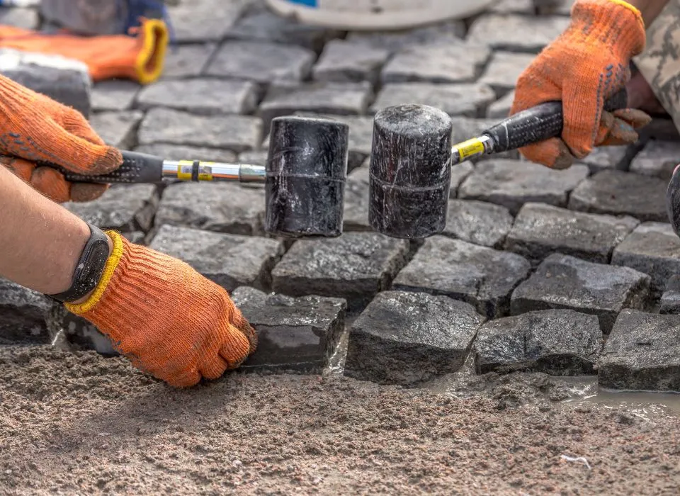 Elegant raised garden walls and stone planters featuring seasonal flowers in a Los Angeles patio by Dream Patios LA.