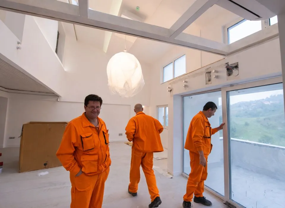 Stunning night view of illuminated panoramic glass doors overlooking a pool and patio in Los Angeles by Dream Patios LA.